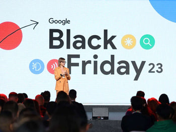 Person speaking on stage at Google Black Friday 2023 event with large screen displaying Black Friday 23 logo.